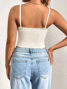 Back view of a white ribbed knit crop camisole paired with light blue washed denim jeans