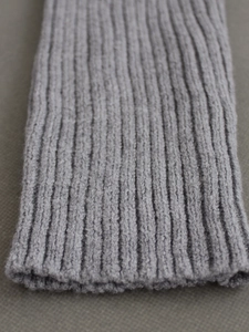 Macro view of grey ribbed knit texture and elastic cuff detail for two-piece sweater