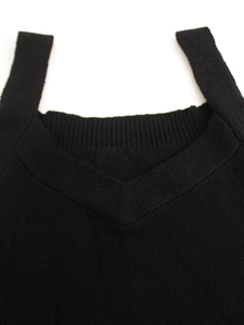 Close-up of deep V-neckline on a black knitted tank top with fine ribbed texture details