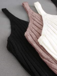 Close-up of three rib-knit camisole tops in black, terracotta, and cream white textures