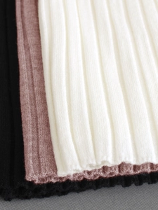 Close-up of ribbed knit fabric texture in black, dusty rose, and off-white colors