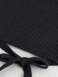 Close-up of black ribbed knit fabric with tie-up bow detail and soft texture