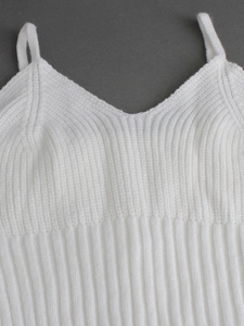 Gros plan du débardeur en tricot blanc à col en V avec texture côtelée verticale