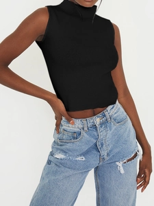 Haut en tricot sans manches à col roulé noir pour femme avec un jean bleu délavé troué
