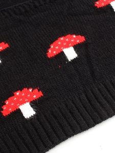 Macro shot of black knitted vest with red mushroom pattern and ribbed hem detailing