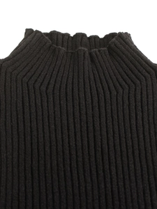 Détail d'un pull noir en maille côtelée à col montant montrant la texture du tissu