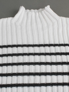 Close-up of white ribbed knit sweater with black stripes and elegant high neckline