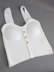 Crop top en maille côtelée blanche avec bretelles fines et boutons en bois sur gris