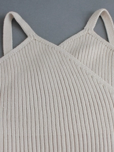 Detailed close-up of a beige ribbed knit tank top with a stylish wrap V-neckline design