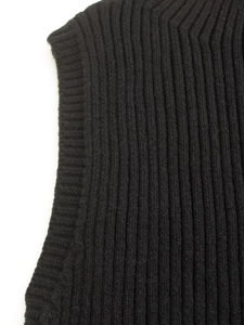 Gros plan sur la maille côtelée verticale et les coutures d'un pull à col roulé noir