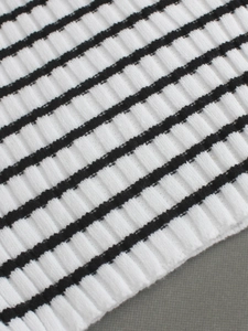 Detail shot of the ribbed knit fabric with classic black and white horizontal stripes