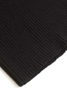 Gros plan macro montrant la texture en maille côtelée et les coutures de la maille noire