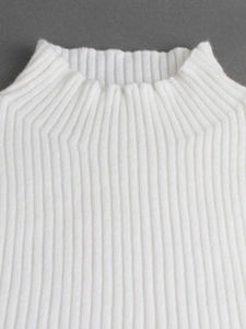 Détail du tissu en maille côtelée blanche sur col haut avec texture verticale élégante