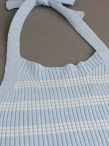 Close-up of light blue and white striped knit halter top with ribbed texture and neck tie