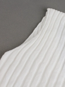 Macro view of white ribbed knit fabric showing vertical texture and high elasticity