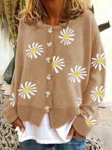Detail of tan knit cardigan featuring white daisy embroidery and tortoiseshell buttons