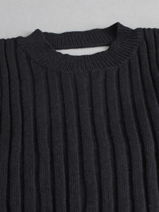 Close-up of black ribbed knit sweater featuring a unique rectangular neckline cutout detail
