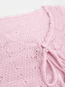 Primer plano de top de ganchillo rosa con patrones calados y bordes festoneados