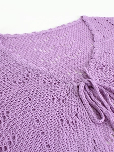 Detalle de cárdigan lavanda de punto calado con cuello en V y detalle de lazo fino