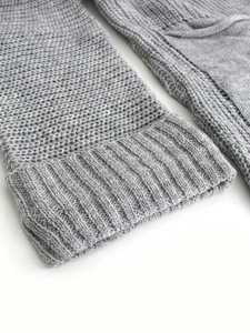 Close-up of light grey knit cardigan sleeve with textured ribbed cuffs for women