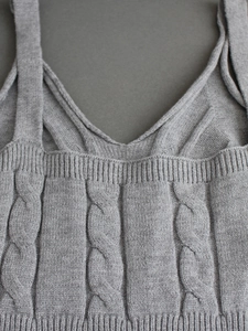 Detailaufnahme des grauen Strick-Tops mit Zopfmuster, Rippsaum und Textur-Details