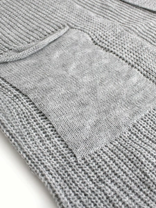 Detailed macro view of light gray knit cardigan featuring ribbed patterns and hollow textures