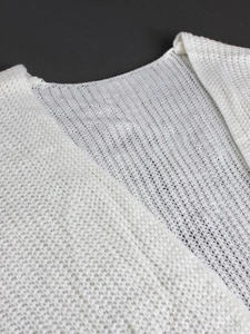 Detailed close-up of white mesh knit fabric texture on a long-sleeve cardigan sweater