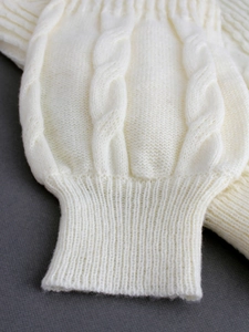 Women's cable knit cardigan with lantern sleeves in cream white close-up view