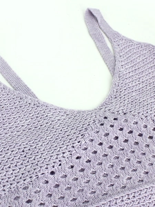 Detail view of lavender knitted dress featuring delicate hollow patterns and thin straps