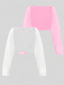 Detail of pink and white knit bolero shrugs showing thick texture and ribbed cuffs