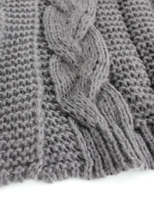Detailed close-up of dark grey cable and honeycomb knit pattern on a warm cardigan