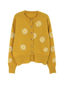 Detailed close-up of mustard yellow cardigan featuring white daisy embroidery and buttons