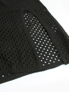 Detailed macro view of black crochet knit fabric with hollow mesh texture and ribbed hem