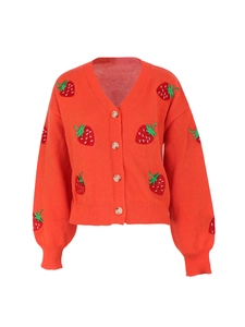 Detail of red knitted cardigan featuring strawberry embroidery and ribbed sleeve cuffs