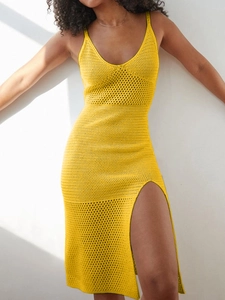 Detail of yellow knit maxi dress showing deep V-neck, thin straps and hollow crochet texture