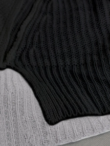 Close-up of thick knit texture and ribbed cuffs on black and grey two-piece set