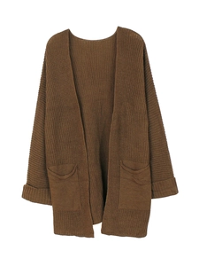 Detail showing deep brown knitted cardigan texture with large front pockets and ribbed cuffs