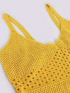 Detailed close-up of yellow knitted strap dress featuring openwork crochet patterns