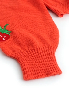 Detail of ribbed cuffs on orange knit cardigan featuring delicate strawberry embroidery