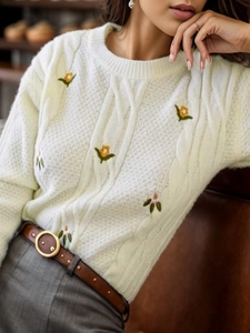 White cable knit sweater with floral embroidery and classic ribbed crew neck
