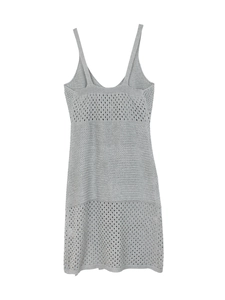 Detail of light gray knitted dress featuring intricate wave and geometric cutout textures