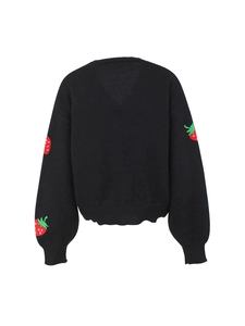 Close-up of vibrant red strawberry embroidery details on black knit cardigan sleeves