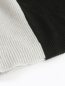 Gros plan sur le tissu en maille noir et blanc montrant la texture épaisse et la couture