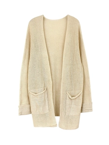 Detail of beige knit cardigan featuring large front pockets and ribbed sleeve cuffs