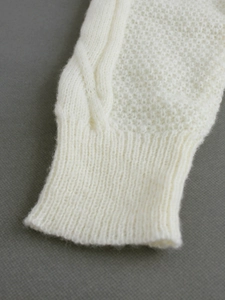 White cable knit sweater with ribbed cuffs and textured mesh patterns in soft wool blend