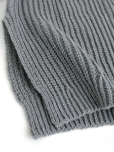 Makro-Detail von grauem Rippstrick-Stoff mit dicker Textur für diesen Rollkragenpullover