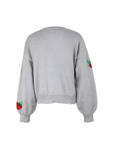 Detail view of the back of a grey knitted cardigan featuring red strawberry embroidery