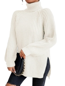 Detailansicht eines cremefarbenen Strickpullovers mit Rollkragen und modischen Seitenschlitzen