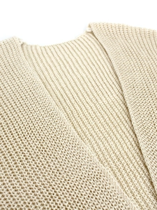 Macro shot of beige knitted sweater collar featuring ribbed texture and intricate mesh patterns