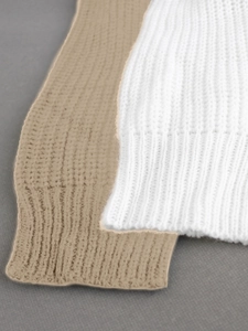 Close-up of white and beige ribbed knit texture on long sleeve beach set cuffs